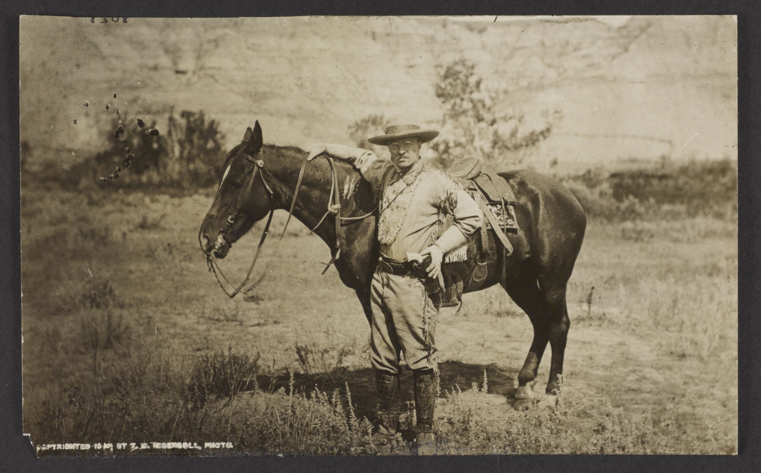 Theodore Roosevelt poses next to his horse Manitou in the Badlands of Dakota Territory